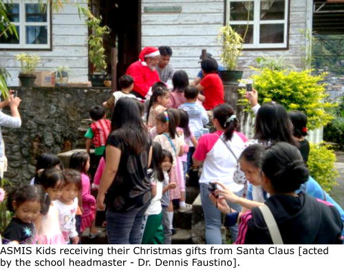 ASMIS Kids receiving their Christmas gifts from Santa Claus [acted by the school headmaster - Dr. Dennis Faustino].